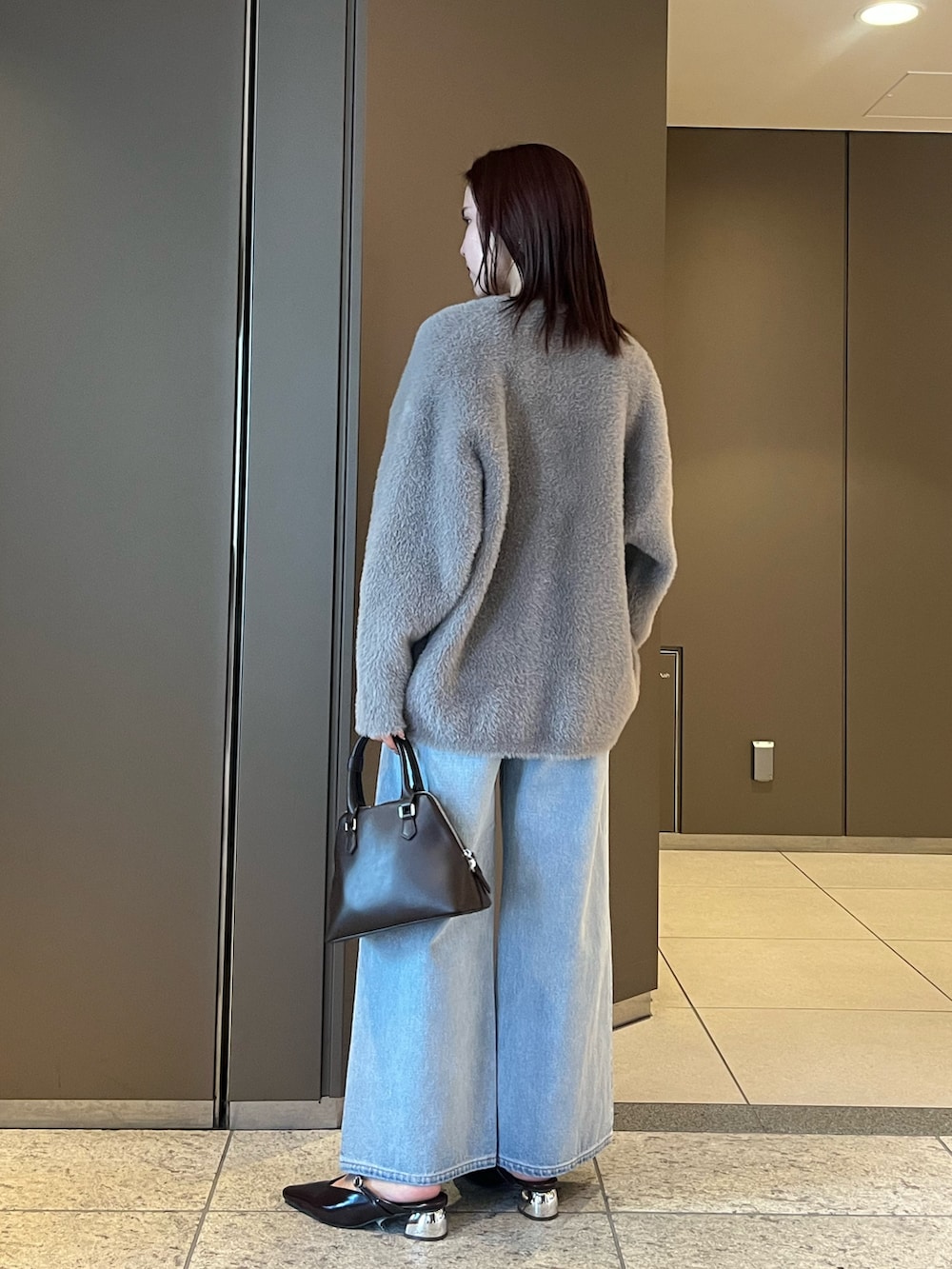 ブルー系のデニムパンツ、ホワイト系のTシャツ/カットソー、ブラウン系のボストンバッグを着用したレディースの夏コーディネートの3枚目の写真