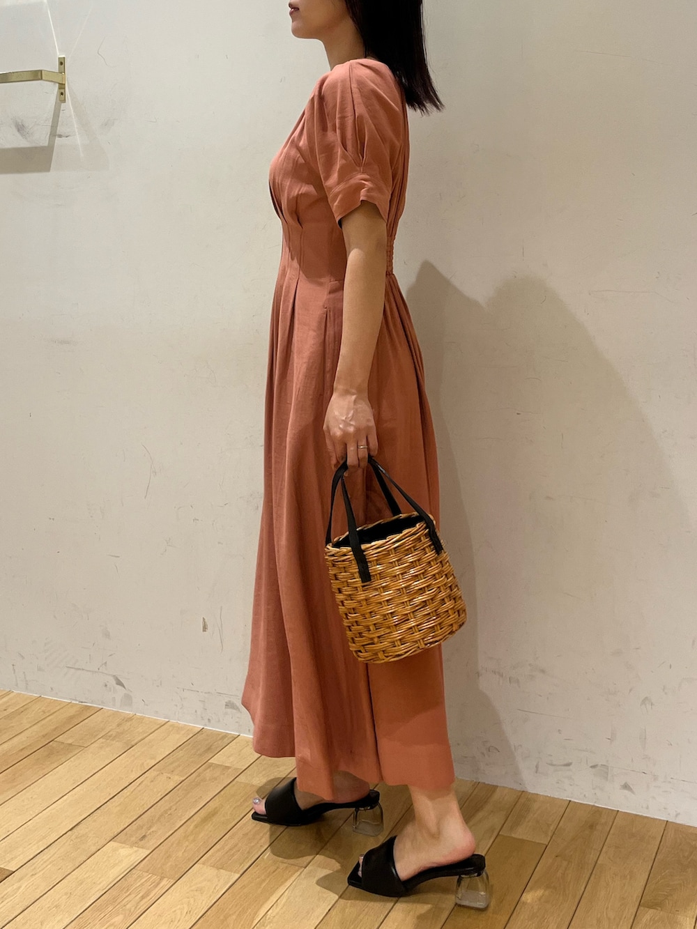 ブラウン系のハンドバッグ、ブラック系のサンダル、ピンク系のワンピースを着用したレディースの夏コーディネートの2枚目の写真