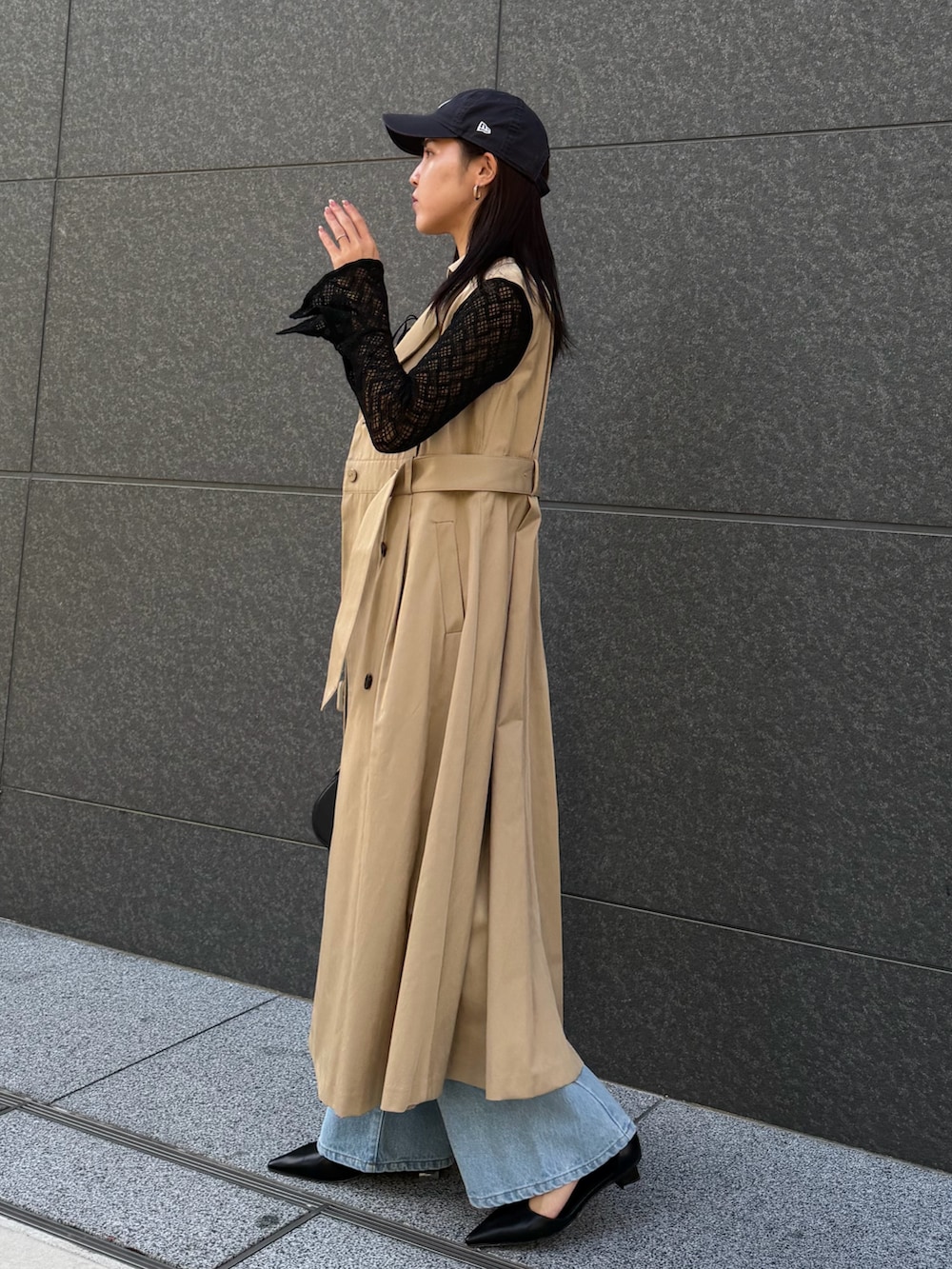 ブラック系のシャツ/ブラウス、ブルー系のデニムパンツ、ベージュ系のトレンチコートを着用したレディースの冬コーディネートの7枚目の写真