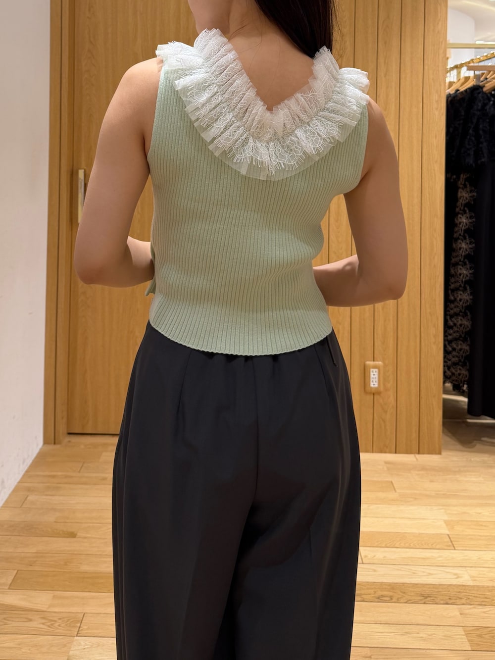 グレー系のその他パンツ、ブラック系のハンドバッグ、グリーン系のニット/セーターを着用したレディースの夏コーディネートの6枚目の写真