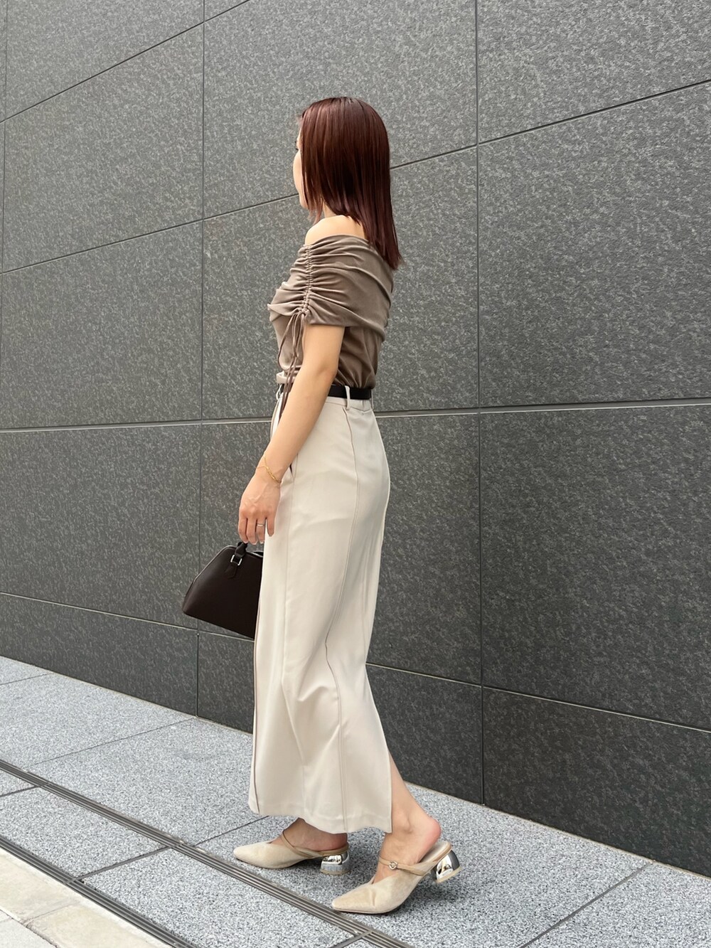 ベージュ系のパンプス、ブラウン系のボストンバッグ、ブラウン系のTシャツ/カットソーを着用したレディースの夏コーディネートの2枚目の写真