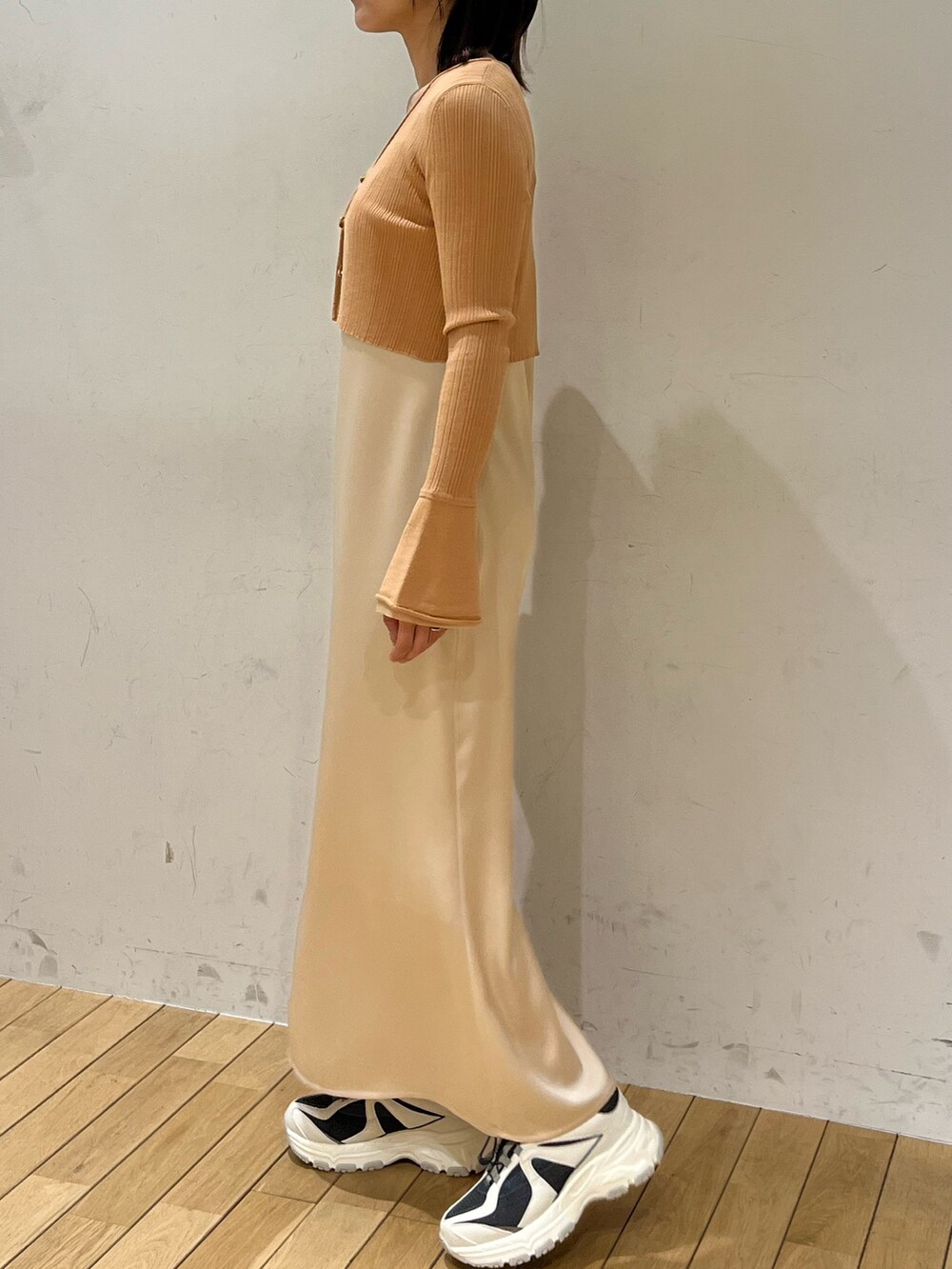 オレンジ系のワンピース、グレー系のスニーカーを着用したレディースの冬コーディネートの2枚目の写真