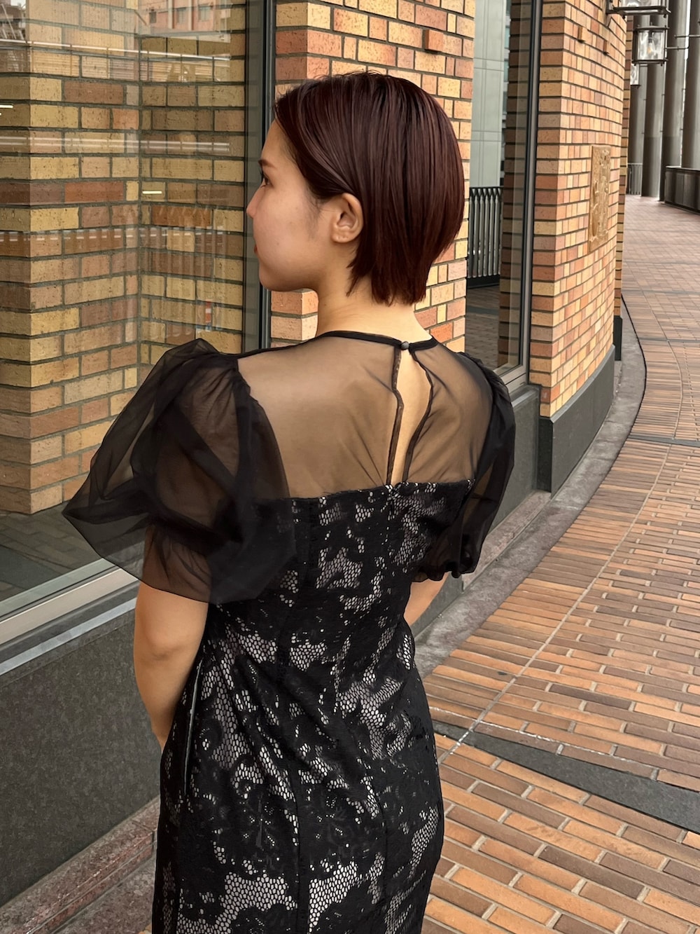 ブラック系のドレス、その他のパンプス、シルバー系のハンドバッグを着用したレディースの冬コーディネートの5枚目の写真