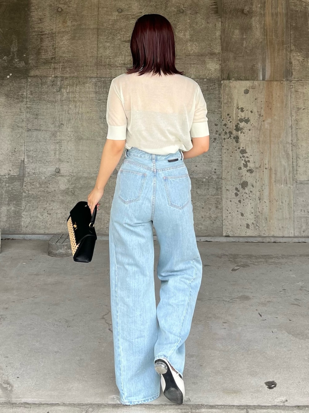 グリーン系のTシャツ/カットソー、ブルー系のデニムパンツ、ブラック系のハンドバッグを着用したレディースの春コーディネートの3枚目の写真