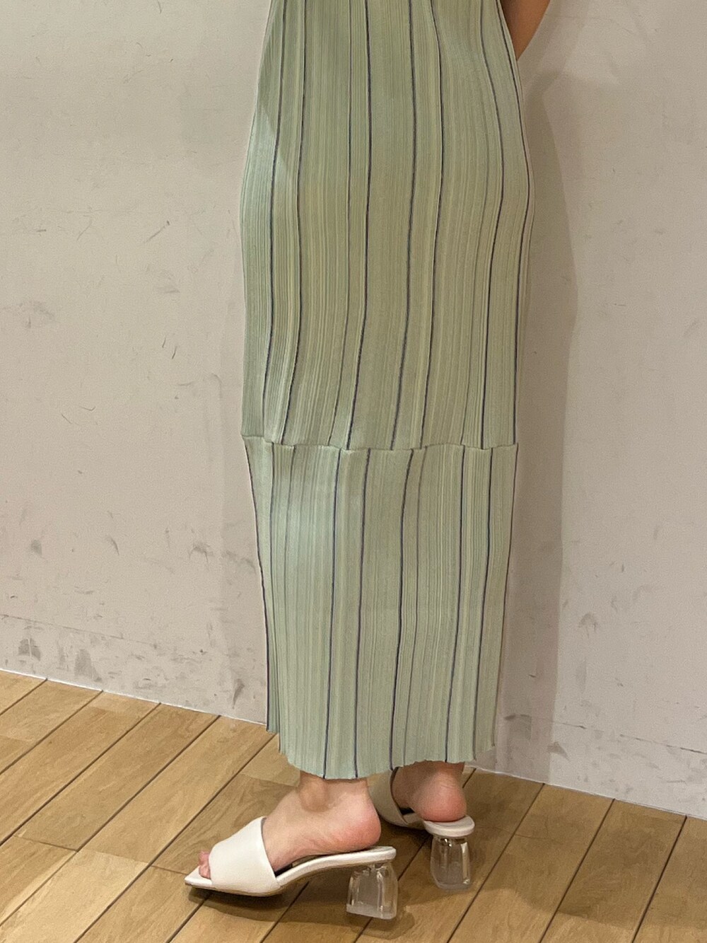 ホワイト系のサンダル、ホワイト系のテーラードジャケット、グリーン系のワンピースを着用したレディースの春コーディネートの7枚目の写真