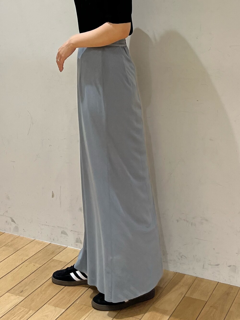 ブルー系のスカート、ブラック系のTシャツ/カットソー、ブラック系のスニーカーを着用したレディースの春コーディネートの7枚目の写真