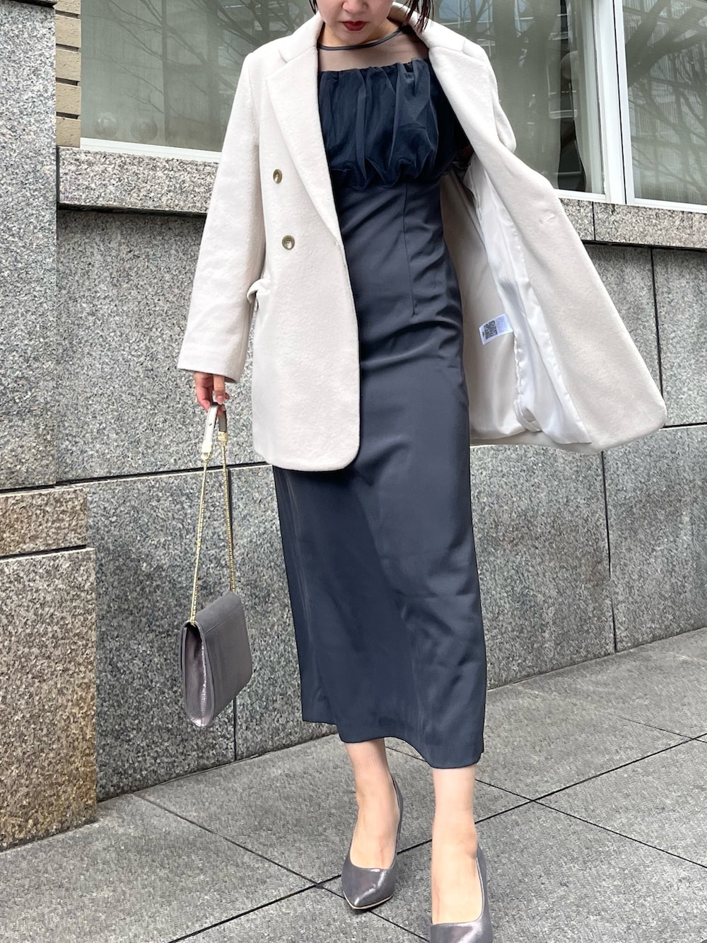 グレー系のドレス、シルバー系のパンプス、シルバー系のハンドバッグを着用したレディースの冬コーディネートの4枚目の写真