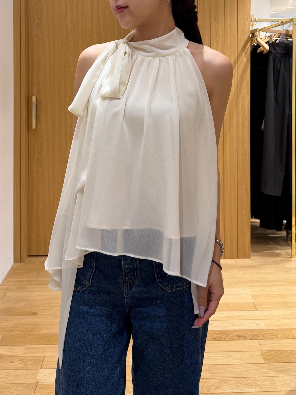 ブルー系のデニムパンツ、ホワイト系のシャツ/ブラウス、グリーン系のパンプスを着用したレディースの夏コーディネートの4枚目の写真