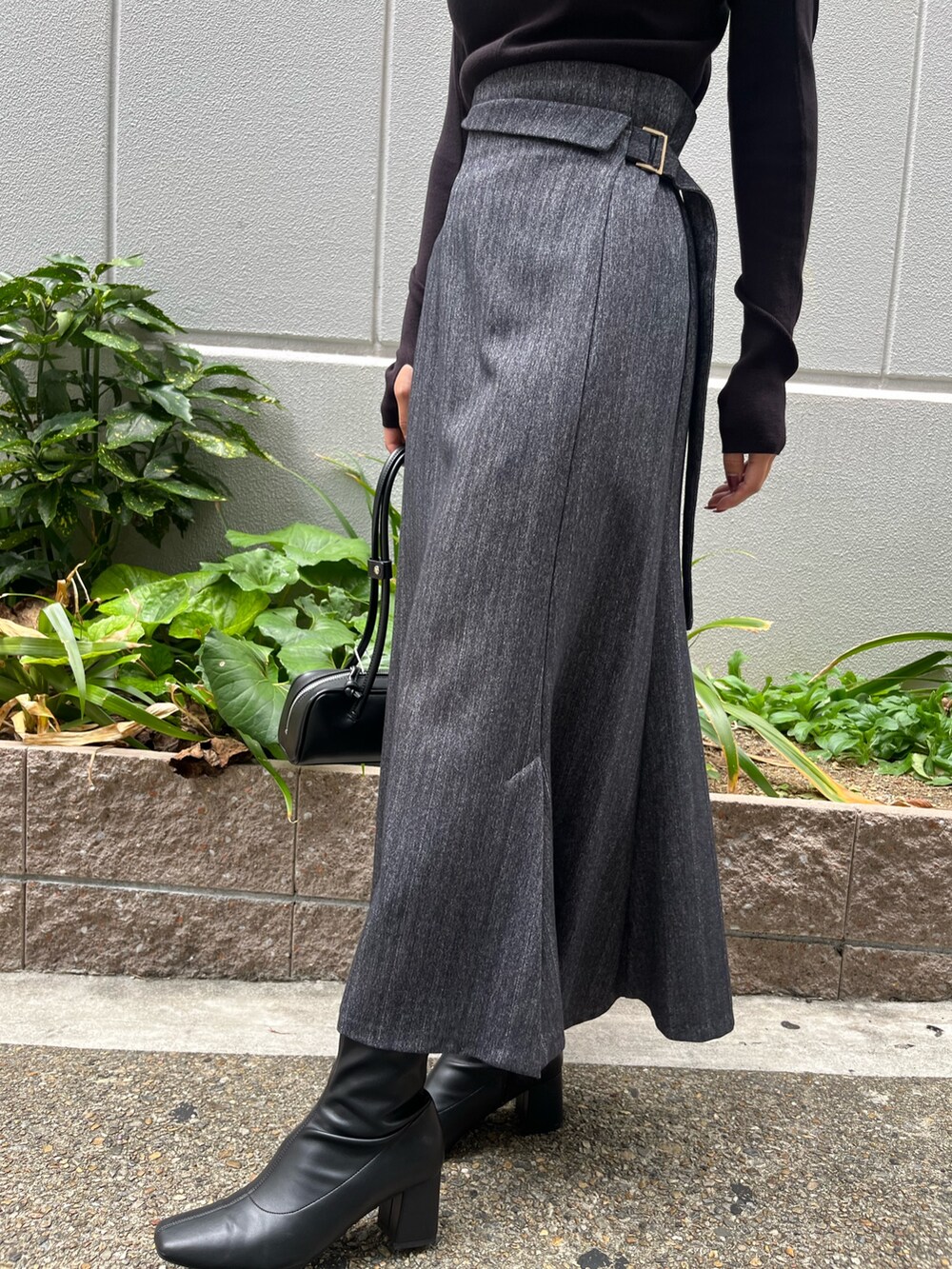 ブラック系のニット/セーター、グレー系のカーディガン/ボレロ、グレー系のスカートを着用したレディースの秋コーディネートの6枚目の写真