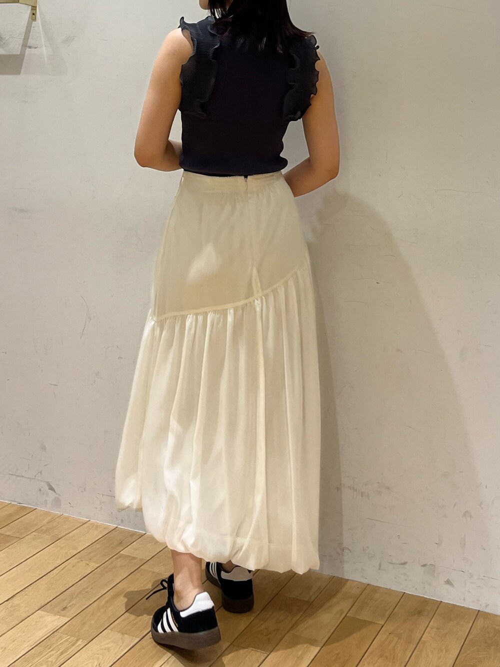 ブラック系のスニーカー、ホワイト系のスカート、グレー系のニット/セーターを着用したレディースの夏コーディネートの3枚目の写真