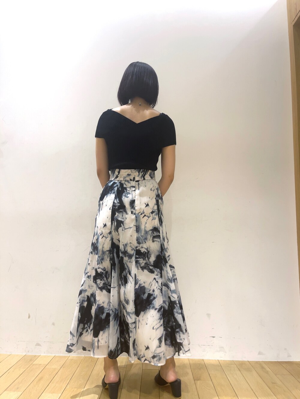 ブラック系のニット/セーター、ブルー系のサンダル、ホワイト系のショルダーバッグを着用したレディースの夏コーディネートの5枚目の写真