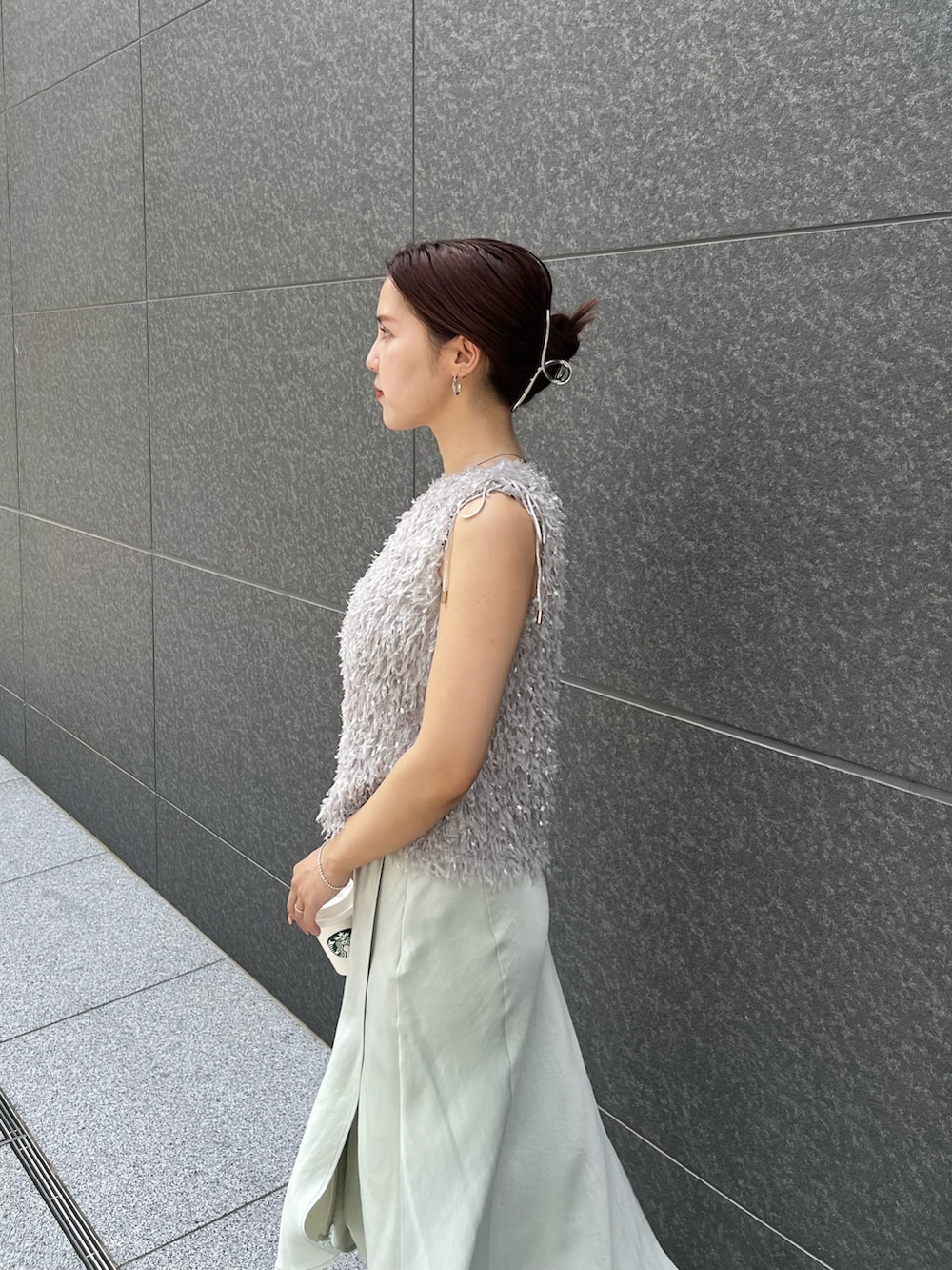 グレー系のTシャツ/カットソー、グリーン系のスカート、ホワイト系のサンダルを着用したレディースの夏コーディネートの5枚目の写真