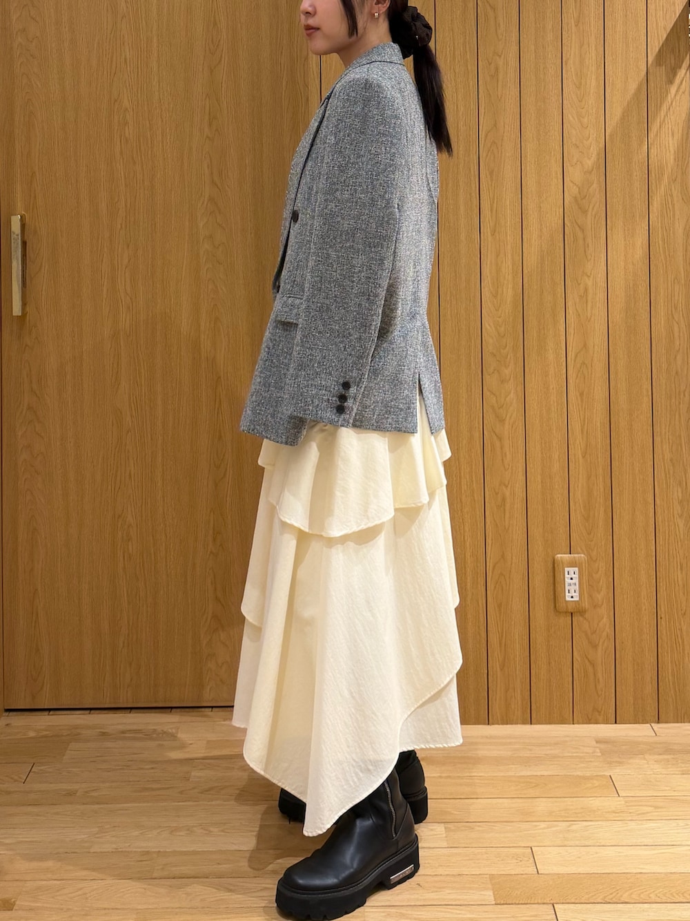 ブラック系のテーラードジャケット、ホワイト系のスカート、ブラック系のニット/セーターを着用したレディースの春コーディネートの2枚目の写真