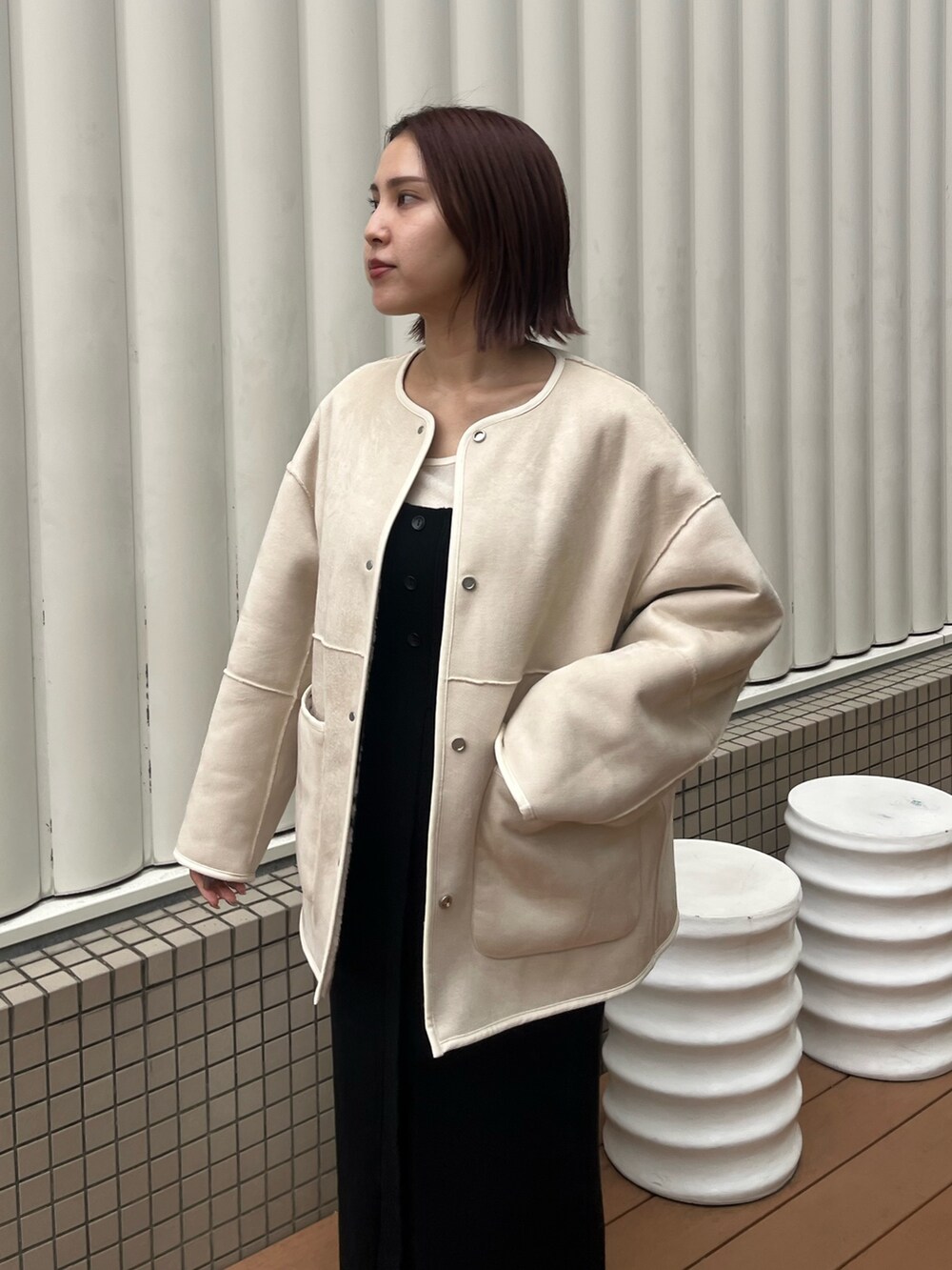 ブラック系のワンピース、ホワイト系のブルゾン、ホワイト系のTシャツ/カットソーを着用したレディースの秋コーディネートの6枚目の写真