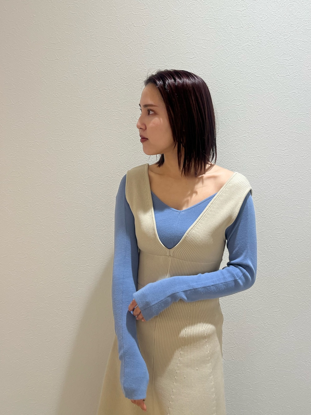 ブラック系のブーツ、ホワイト系のジャンパースカート、ブルー系のニット/セーターを着用したレディースの冬コーディネートの4枚目の写真