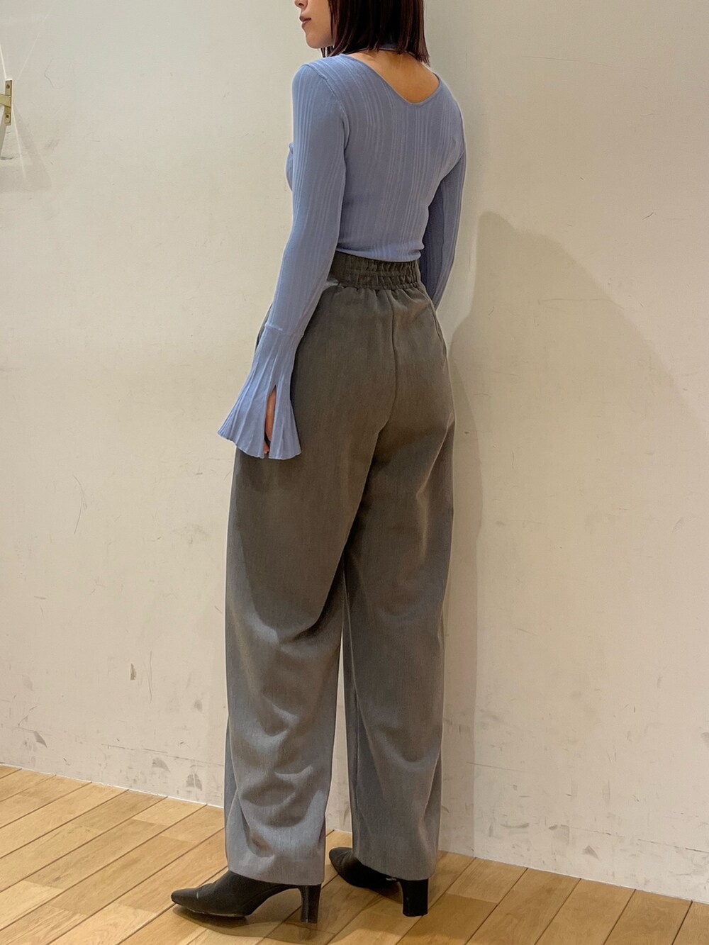 グレー系のその他パンツ、ブルー系のニット/セーター、ブラック系のブーツを着用したレディースの冬コーディネートの3枚目の写真