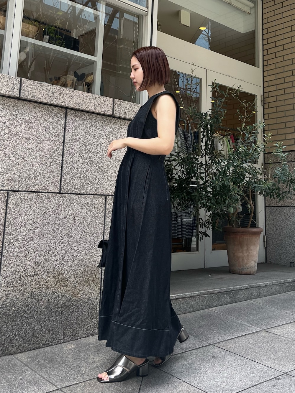 ブラック系のワンピース、その他のサンダル、ブラック系のハンドバッグを着用したレディースの春コーディネートの3枚目の写真