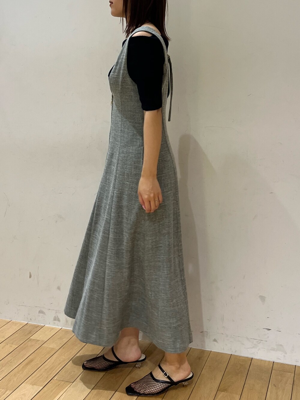 ブルー系のニット/セーター、ブラック系のサンダル、グリーン系のジャンパースカートを着用したレディースの春コーディネートの2枚目の写真