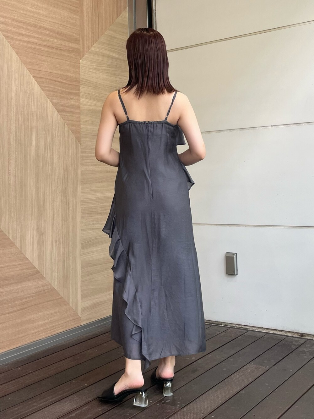 グレー系のワンピース、ブラウン系のハンドバッグ、ブラック系のサンダルを着用したレディースの夏コーディネートの3枚目の写真