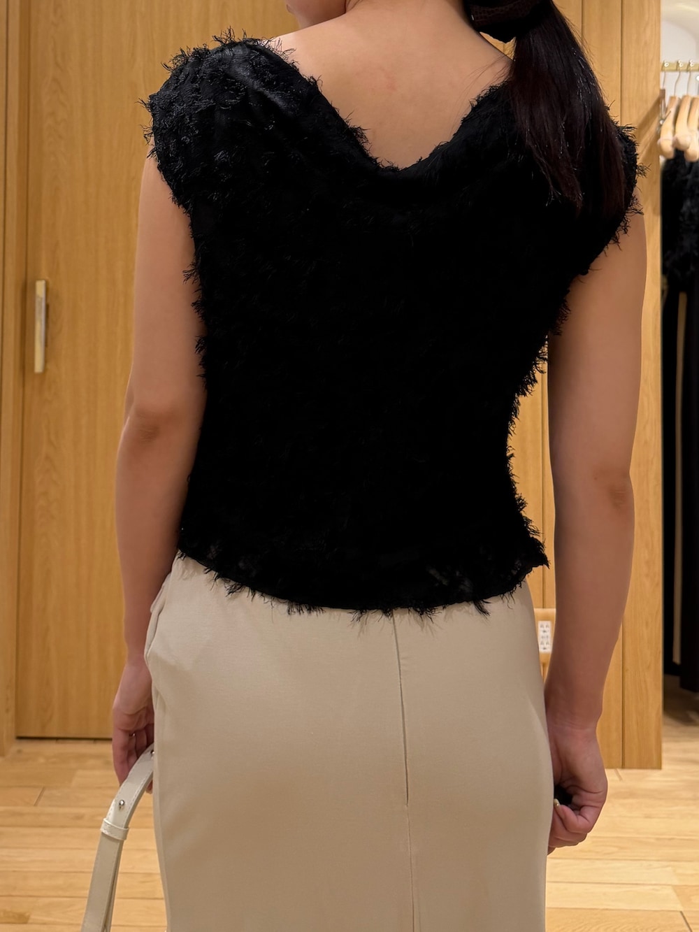 ブラック系のパンプス、ホワイト系のハンドバッグ、ブラック系のシャツ/ブラウスを着用したレディースの春コーディネートの5枚目の写真