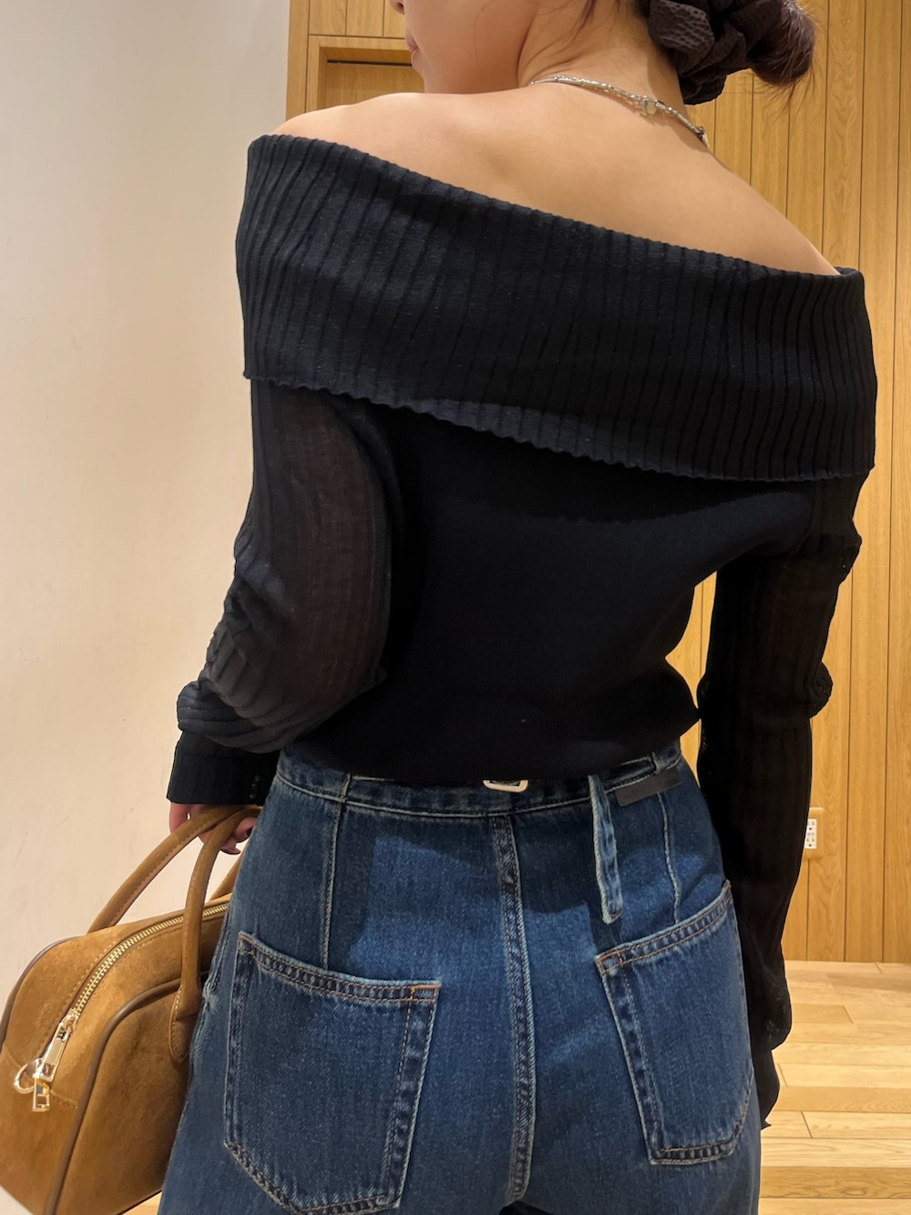 ブラウン系のパンプス、ブラウン系のハンドバッグ、ブルー系のデニムパンツを着用したレディースの秋コーディネートの5枚目の写真