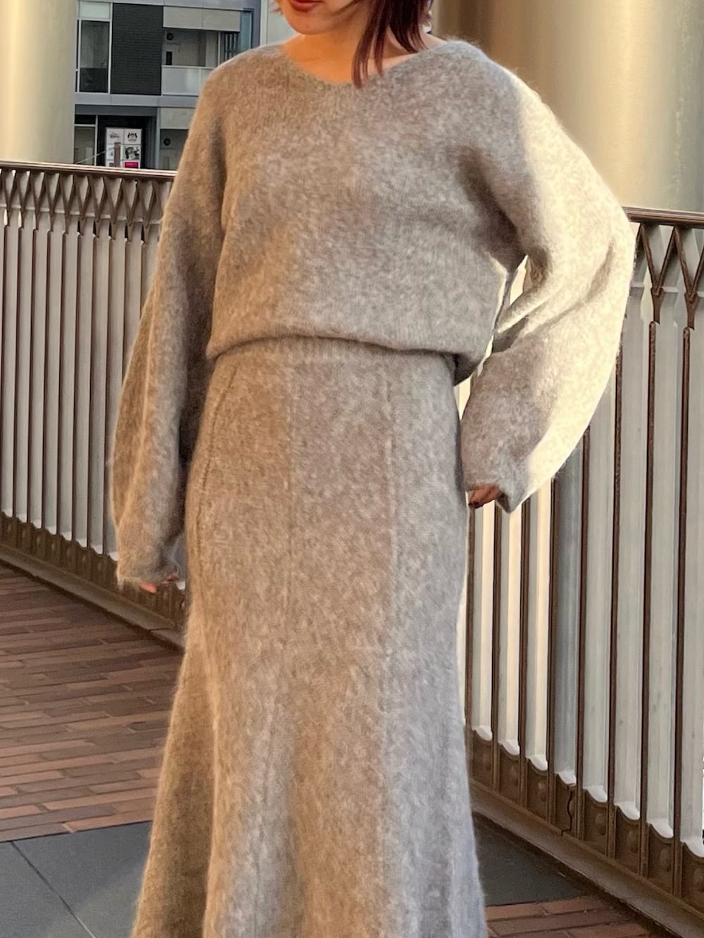 グレー系のスカート、グレー系のニット/セーターを着用したレディースの秋コーディネートの5枚目の写真