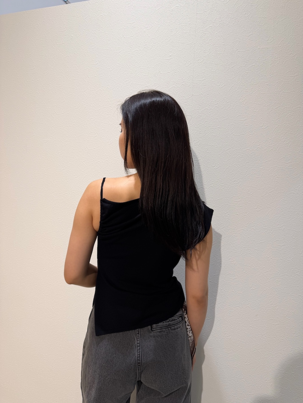 ブラック系のパンプス、ブラウン系のハンドバッグ、ブラック系のデニムパンツを着用したレディースの夏コーディネートの6枚目の写真
