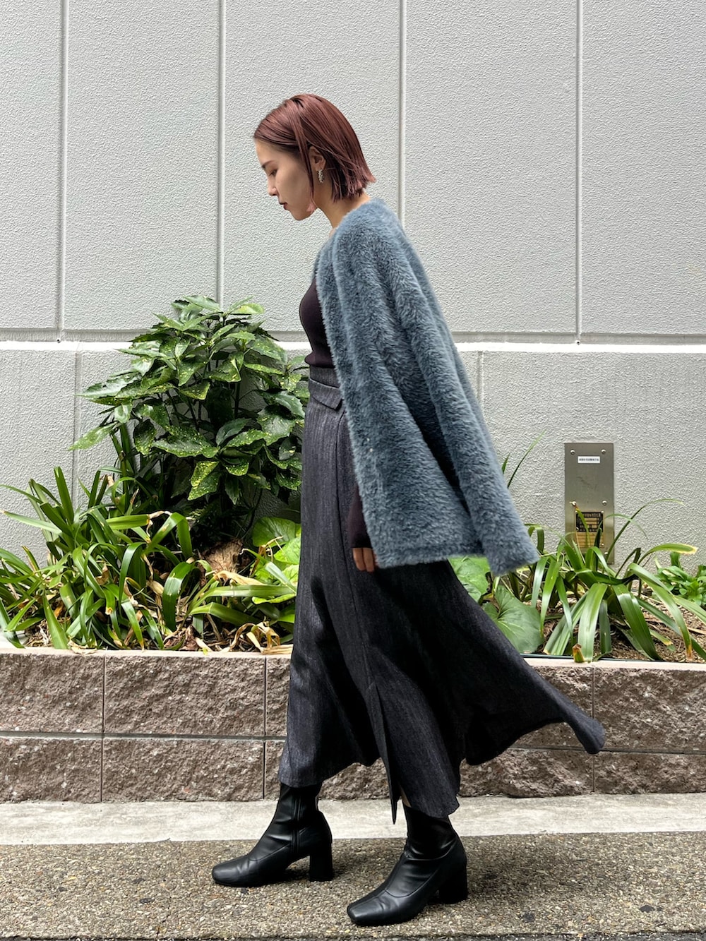 ブラック系のニット/セーター、グレー系のカーディガン/ボレロ、グレー系のスカートを着用したレディースの秋コーディネートの2枚目の写真