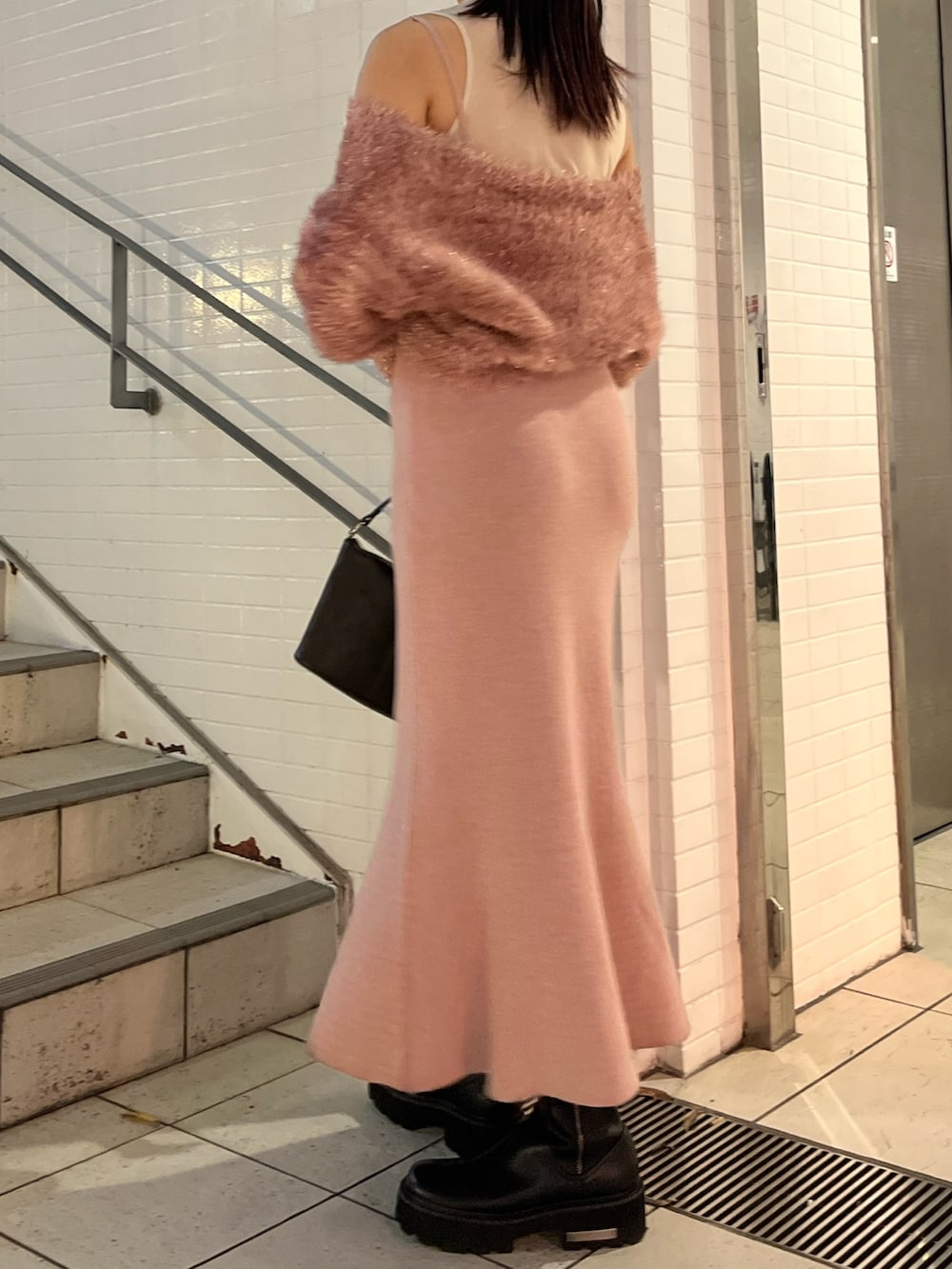 ピンク系のワンピース、ブラウン系のハンドバッグを着用したレディースの冬コーディネートの3枚目の写真