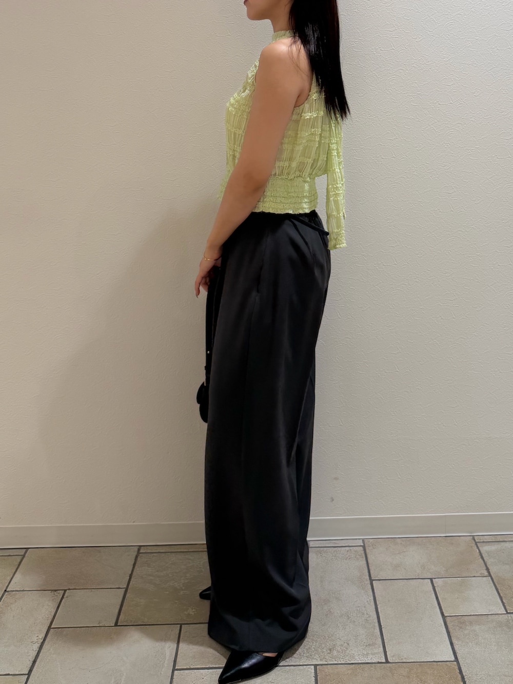 グレー系のその他パンツ、グリーン系のシャツ/ブラウス、ブラック系のハンドバッグを着用したレディースの夏コーディネートの2枚目の写真