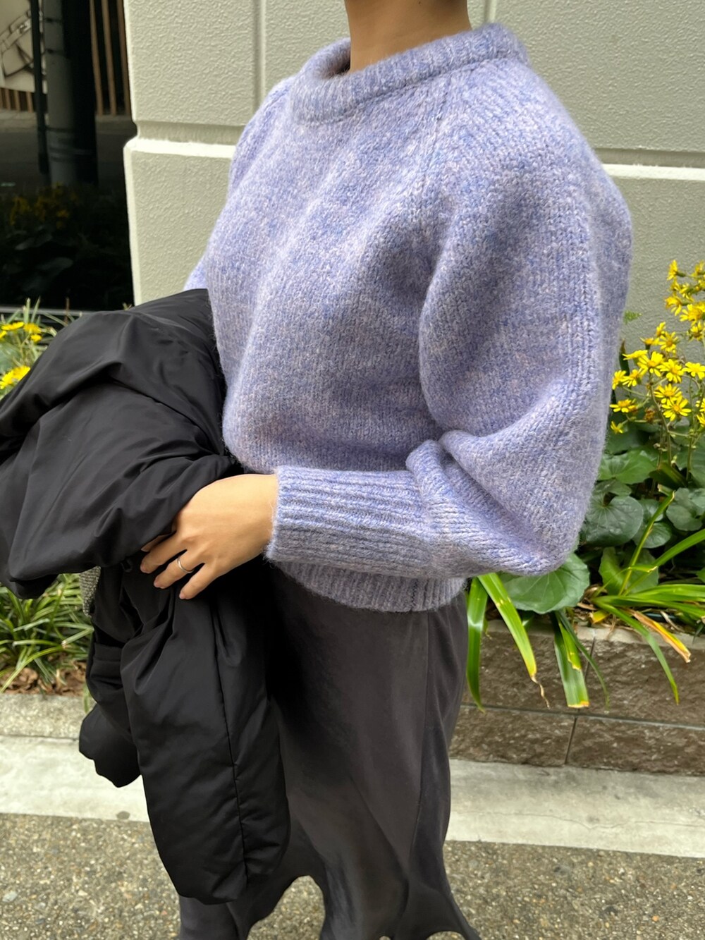 グレー系のスカート、パープル系のニット/セーター、ブラック系のダウンジャケット/コートを着用したレディースの冬コーディネートの6枚目の写真