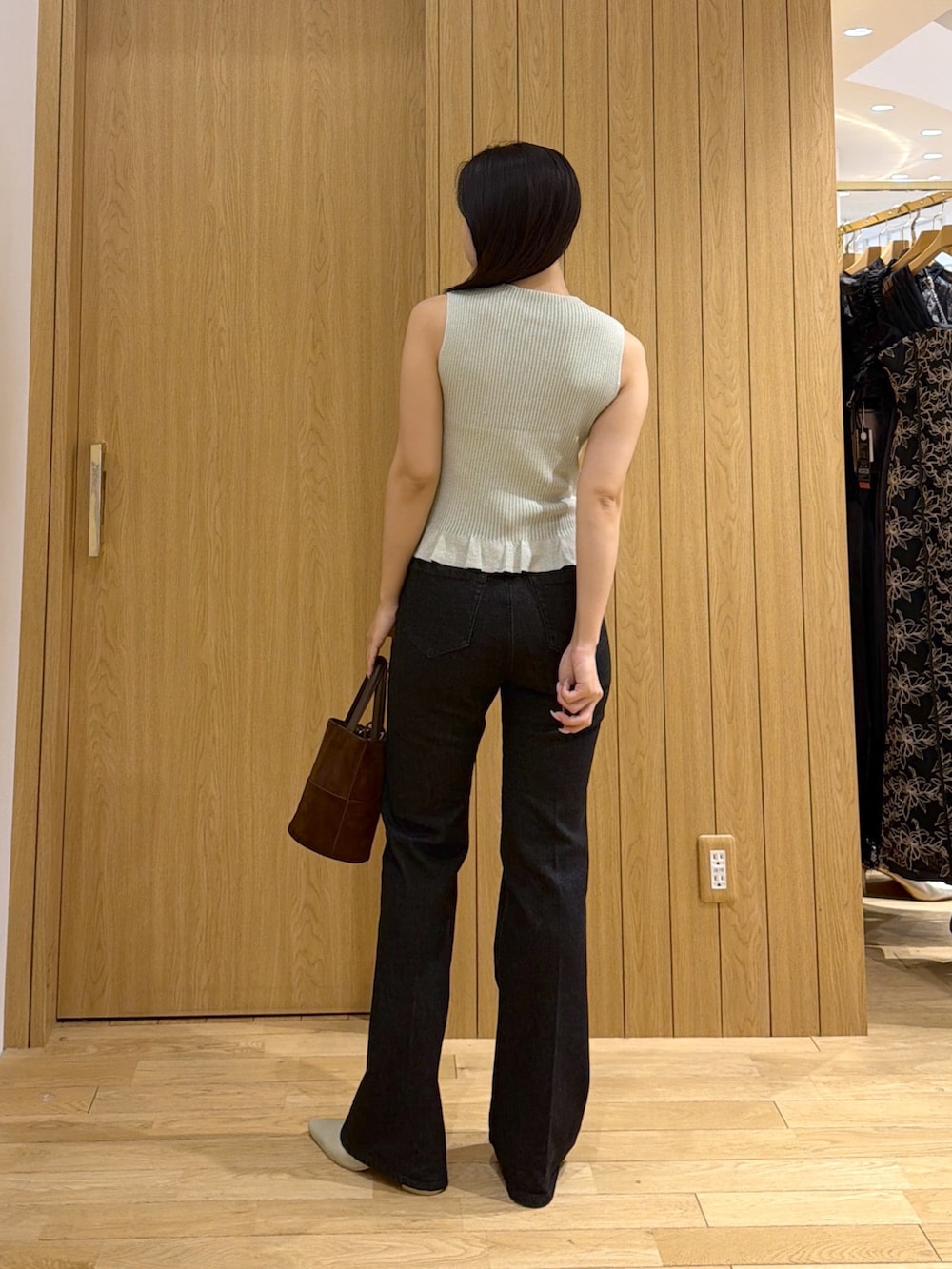 ブラック系のデニムパンツ、ブラウン系のハンドバッグ、グリーン系のパンプスを着用したレディースの夏コーディネートの3枚目の写真