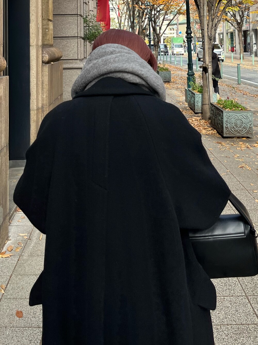 ホワイト系のワンピース、ブラック系のチェスターコート、ブラック系のハンドバッグを着用したレディースの冬コーディネートの8枚目の写真