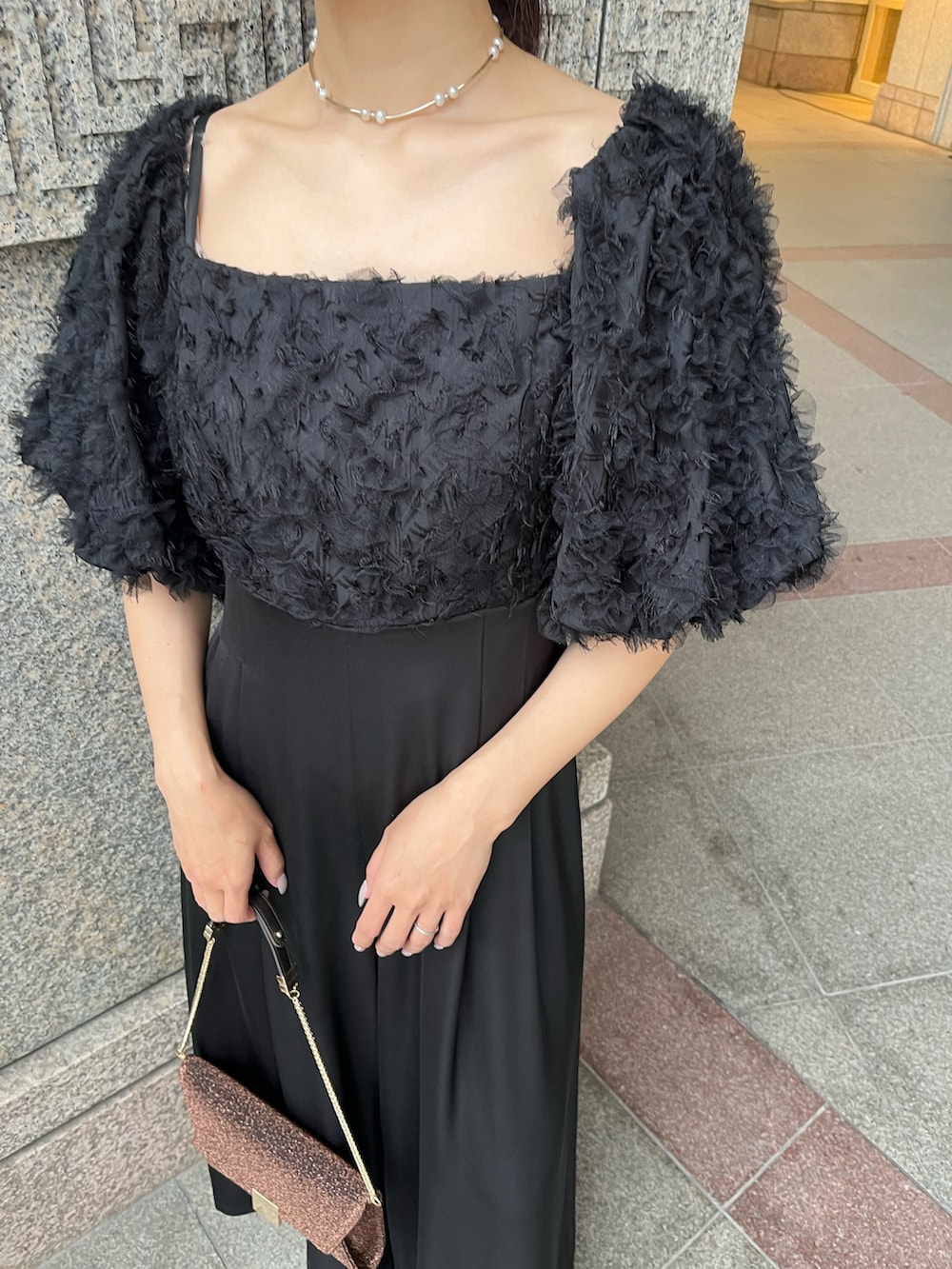 その他のパンプス、ブラック系のパンツドレス、その他のクラッチバッグを着用したレディースの冬コーディネートの7枚目の写真