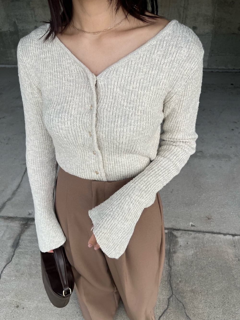 ブラウン系のその他パンツ、ブラウン系のハンドバッグ、ベージュ系のニット/セーターを着用したレディースの冬コーディネートの6枚目の写真