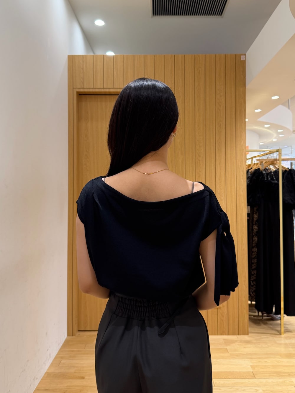 グレー系のその他パンツ、ブラック系のニット/セーター、ホワイト系のハンドバッグを着用したレディースの夏コーディネートの6枚目の写真