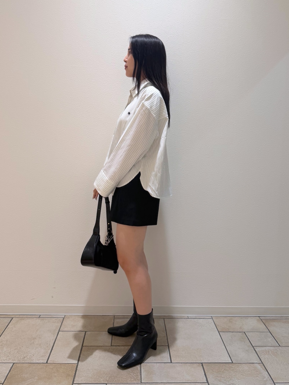 ブラック系のその他パンツ、ホワイト系のシャツ/ブラウス、ブラック系のブーツを着用したレディースの秋コーディネートの2枚目の写真