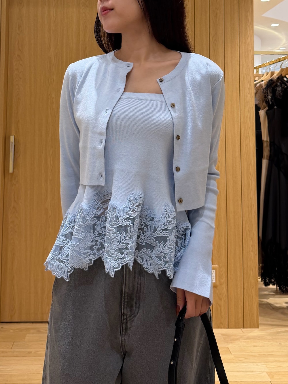グレー系のデニムパンツ、ブルー系のニット/セーター、ブラック系のブーツを着用したレディースの秋コーディネートの4枚目の写真