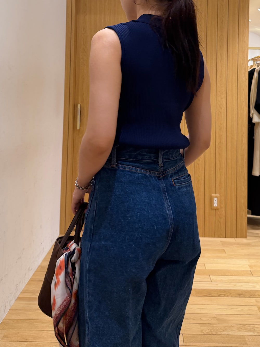 ブルー系のデニムパンツ、ブルー系のニット/セーター、ブラウン系のサンダルを着用したレディースの夏コーディネートの5枚目の写真