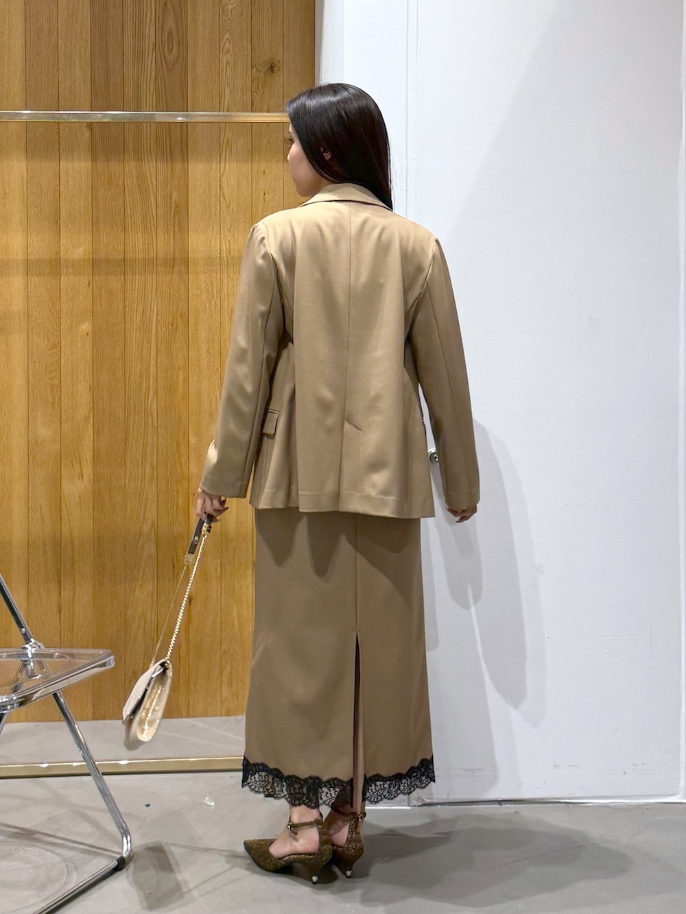 ベージュ系のワンピース、その他のパンプス、ゴールド系のクラッチバッグを着用したレディースの秋コーディネートの3枚目の写真