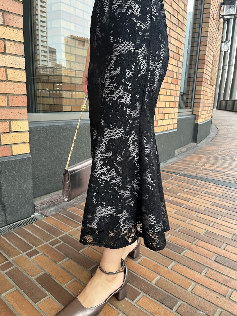 ブラック系のドレス、その他のパンプス、シルバー系のハンドバッグを着用したレディースの冬コーディネートの8枚目の写真