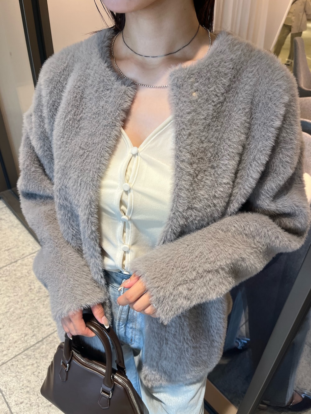 ブルー系のデニムパンツ、ホワイト系のTシャツ/カットソー、ブラウン系のボストンバッグを着用したレディースの夏コーディネートの6枚目の写真