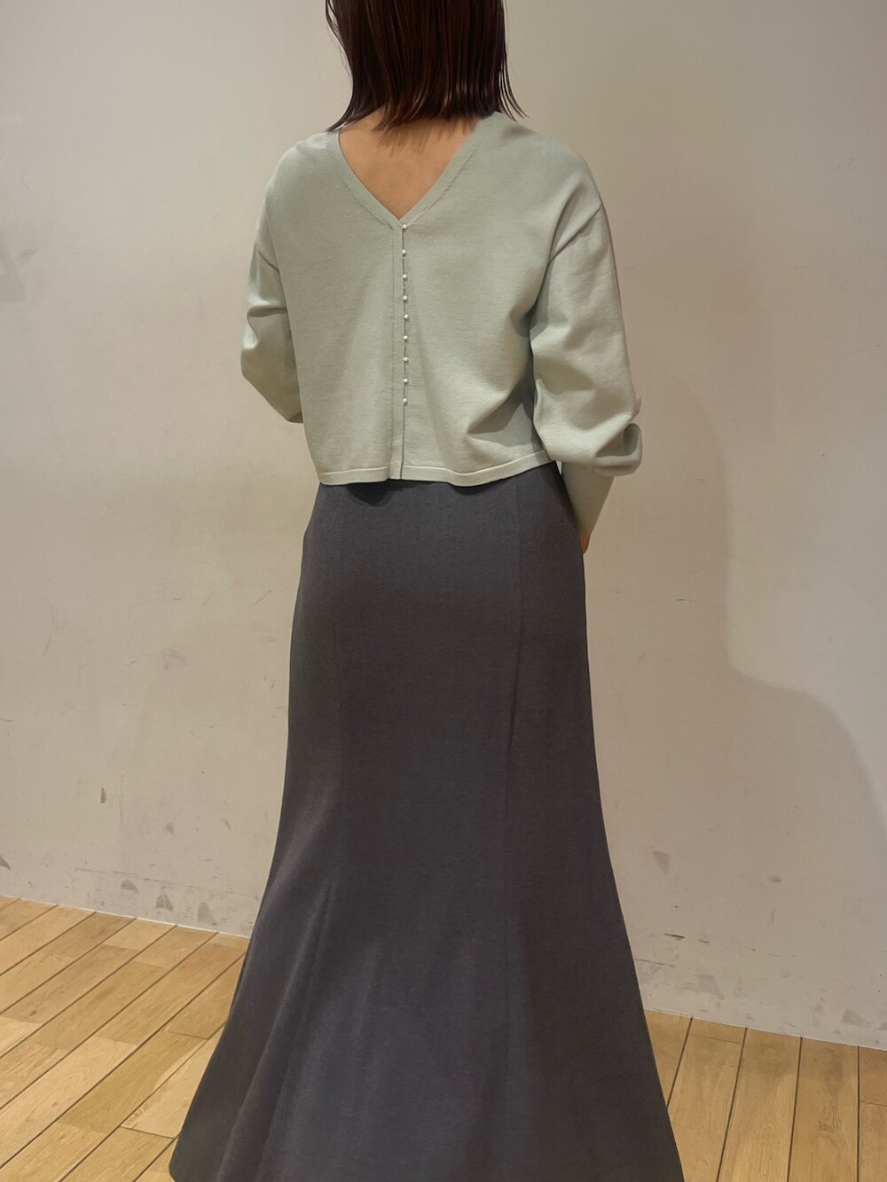 グリーン系のニット/セーター、グレー系のスカート、ブラック系のブーツを着用したレディースの冬コーディネートの5枚目の写真