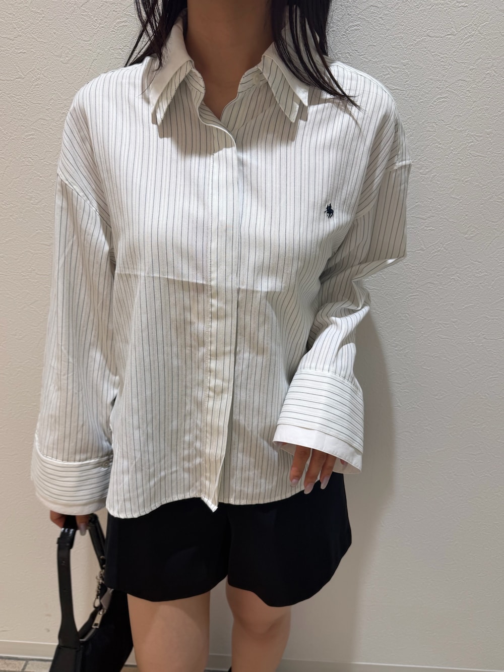 ブラック系のその他パンツ、ホワイト系のシャツ/ブラウス、ブラック系のブーツを着用したレディースの秋コーディネートの6枚目の写真