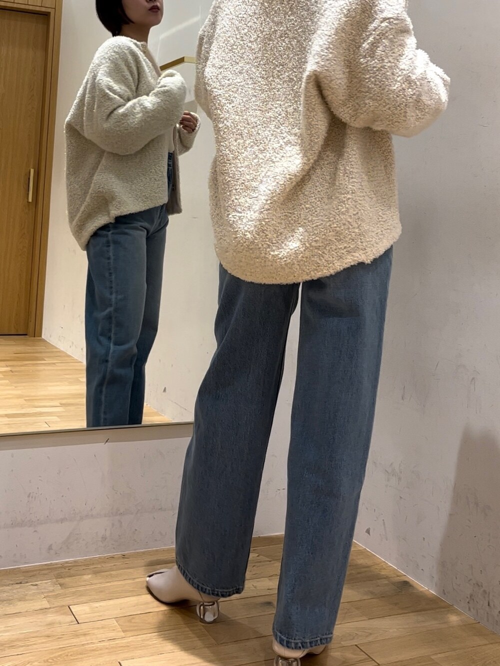 ホワイト系のパンプス、ブルー系のデニムパンツ、ホワイト系のニット/セーターを着用したレディースの冬コーディネートの2枚目の写真