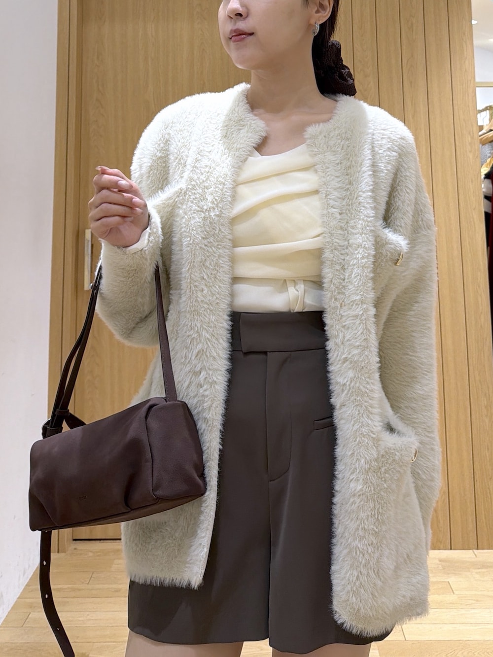 ホワイト系のTシャツ/カットソー、ホワイト系のカーディガン/ボレロ、ブラック系のブーツを着用したレディースの秋コーディネートの8枚目の写真