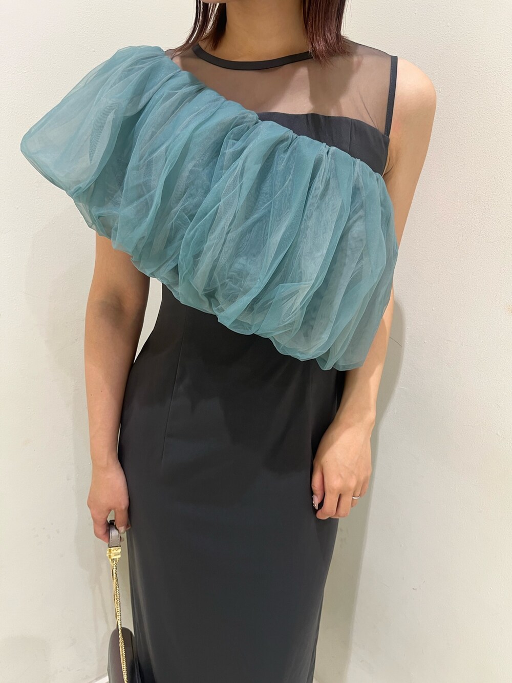 シルバー系のクラッチバッグ、シルバー系のパンプス、グレー系のドレスを着用したレディースの冬コーディネートの8枚目の写真