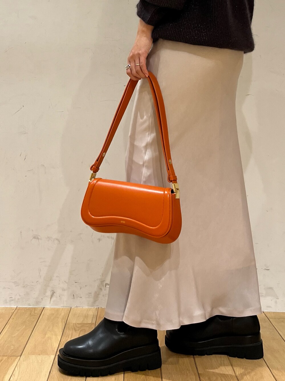 ホワイト系のスカート、オレンジ系のショルダーバッグ、ブラック系のブーツを着用したレディースの秋コーディネートの7枚目の写真