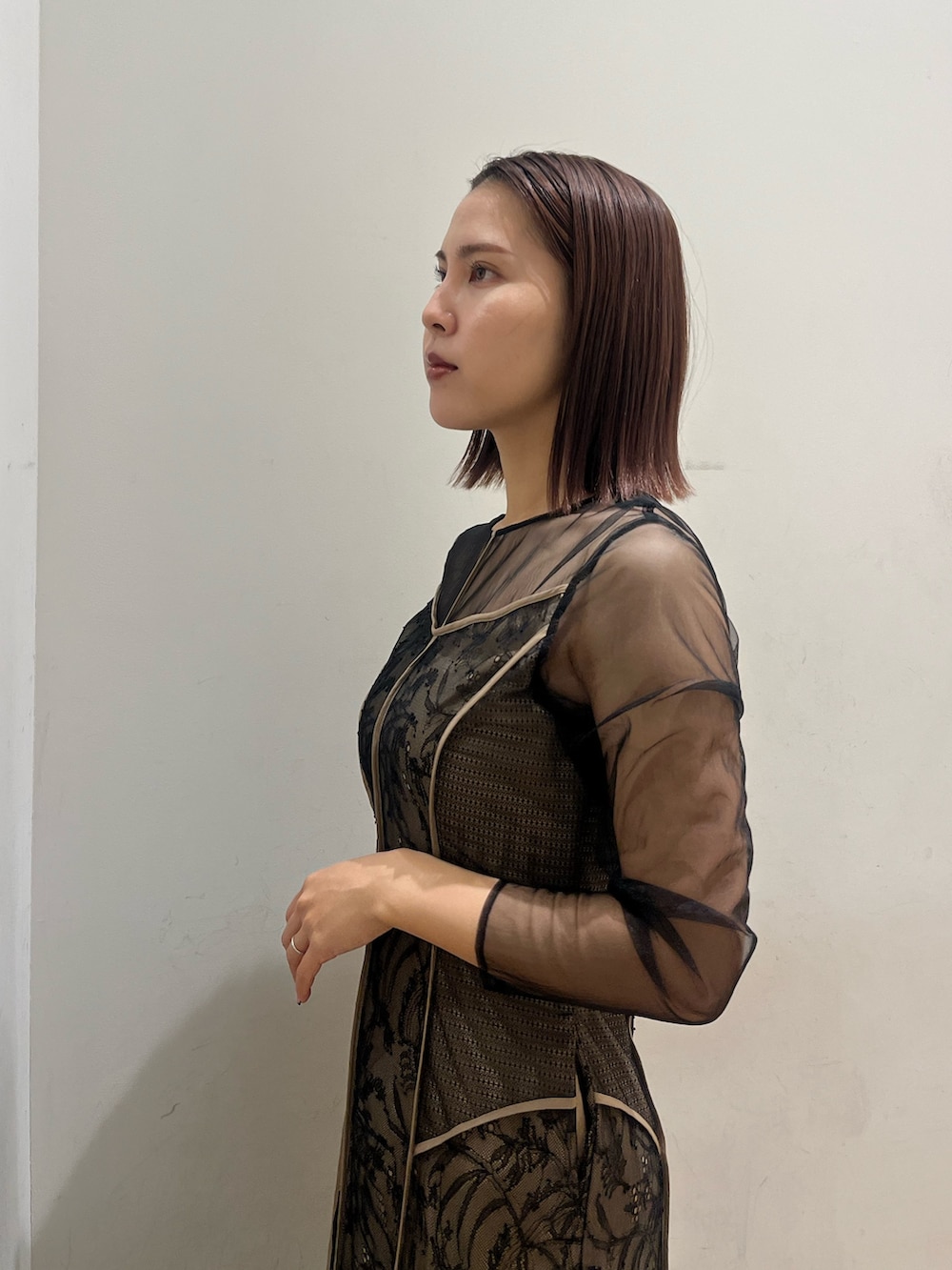 ゴールド系のパンプス、ブラック系のドレスを着用したレディースの冬コーディネートの5枚目の写真