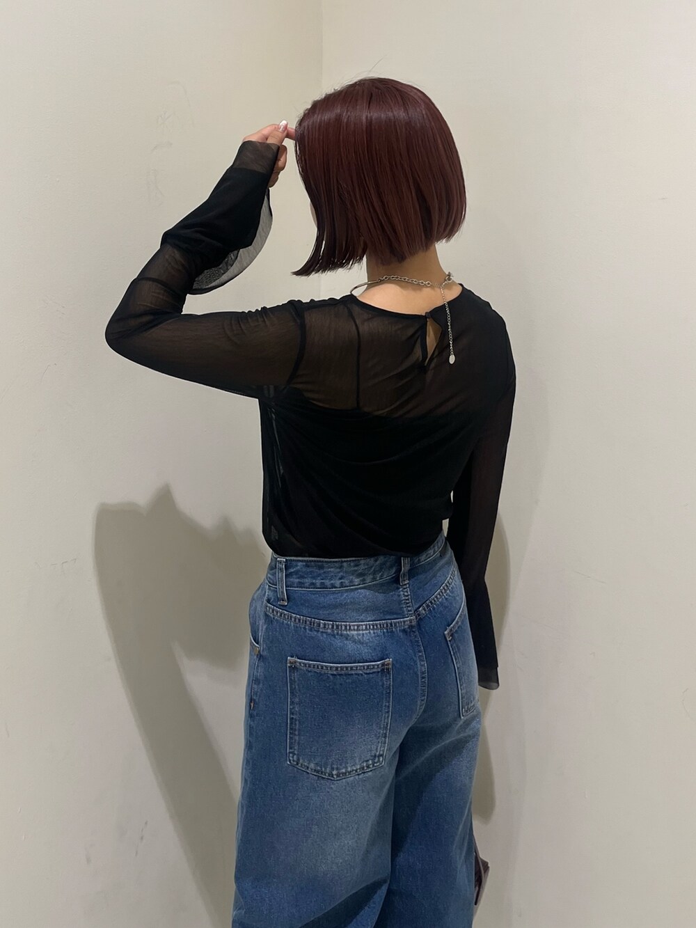 ブルー系のデニムパンツ、レッド系のショルダーバッグ、ブラック系のブーツを着用したレディースの秋コーディネートの8枚目の写真